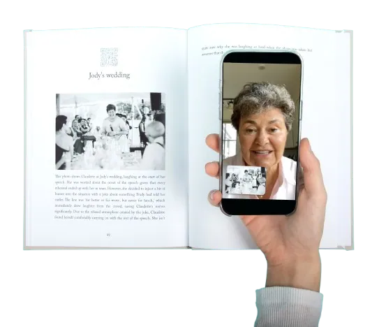 Open Remento book with a phone held over it, playing a video of an older woman