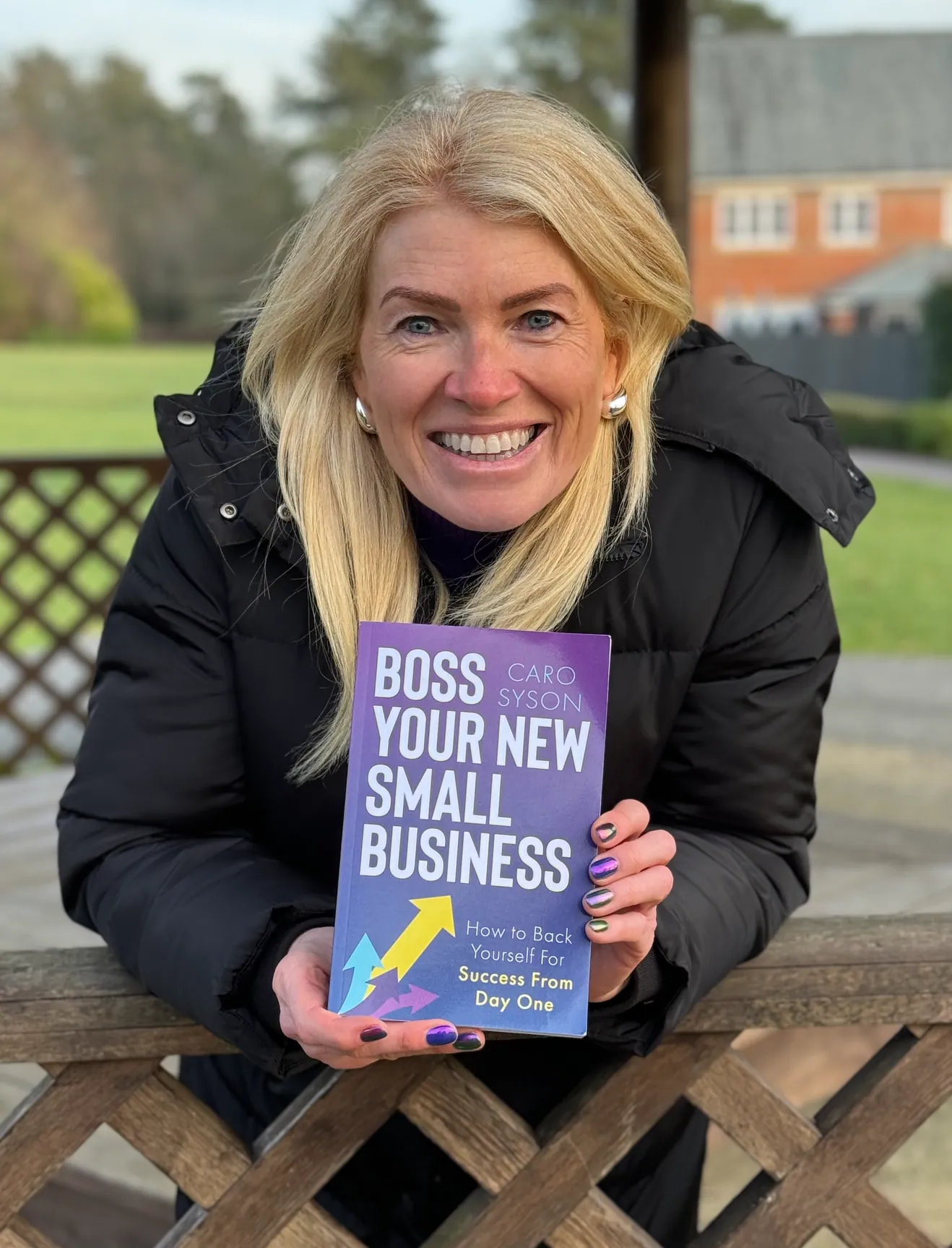 Caro Syson holding her book Boss Your New Small Business