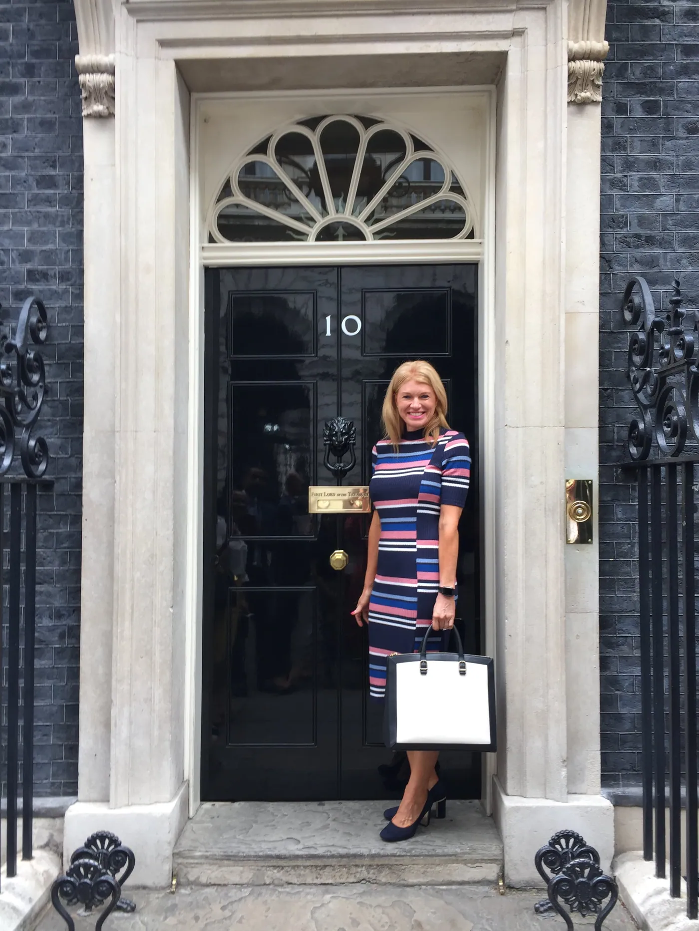 Caro Syson, founder of Your Final Matters, standing at a black front door with the number 10 on it