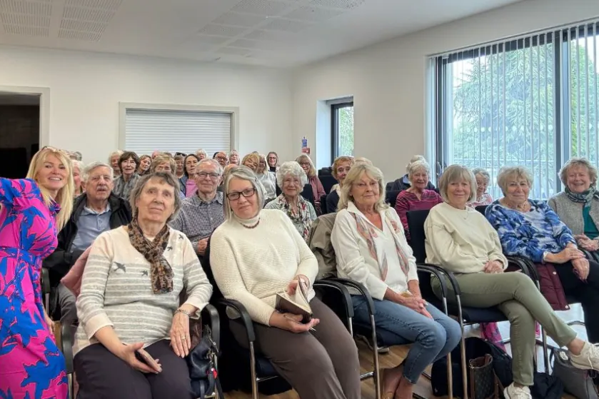 Audience seated in rows at a talk in a community hall