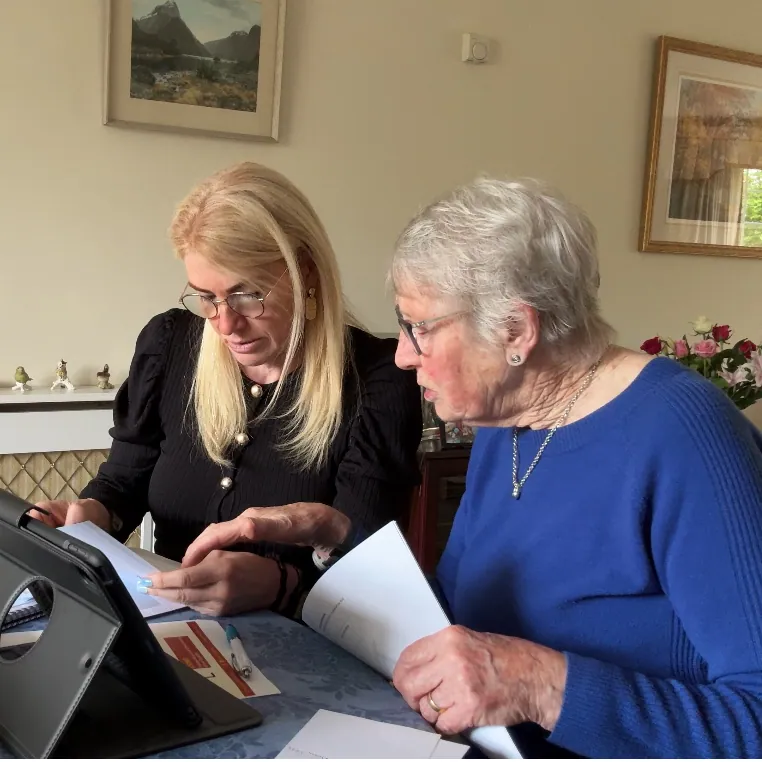 Caro Syson, founder of Your Final Matters, going through paperwork with an older woman at a table