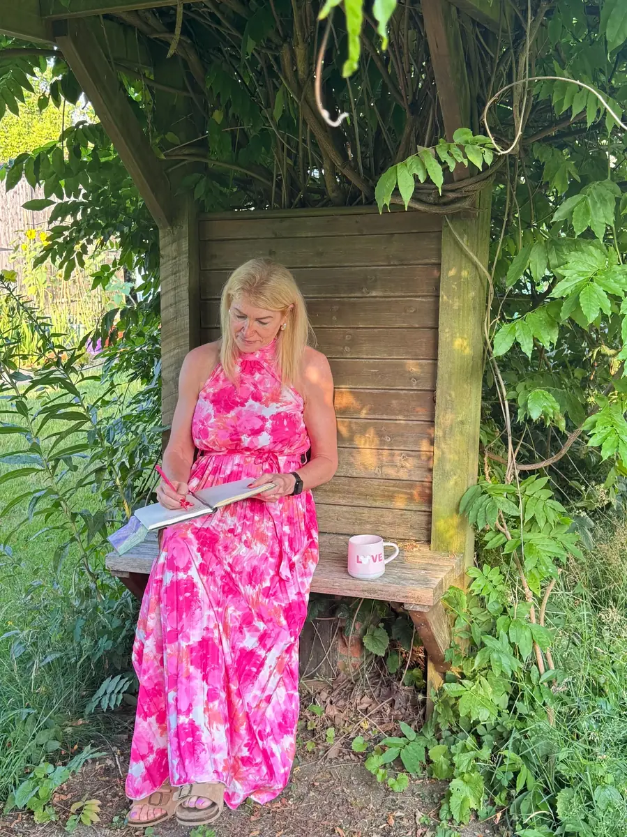 Caro Syson founder of Your Final Matters sitting in garden writing - Letter of Wishes workshop