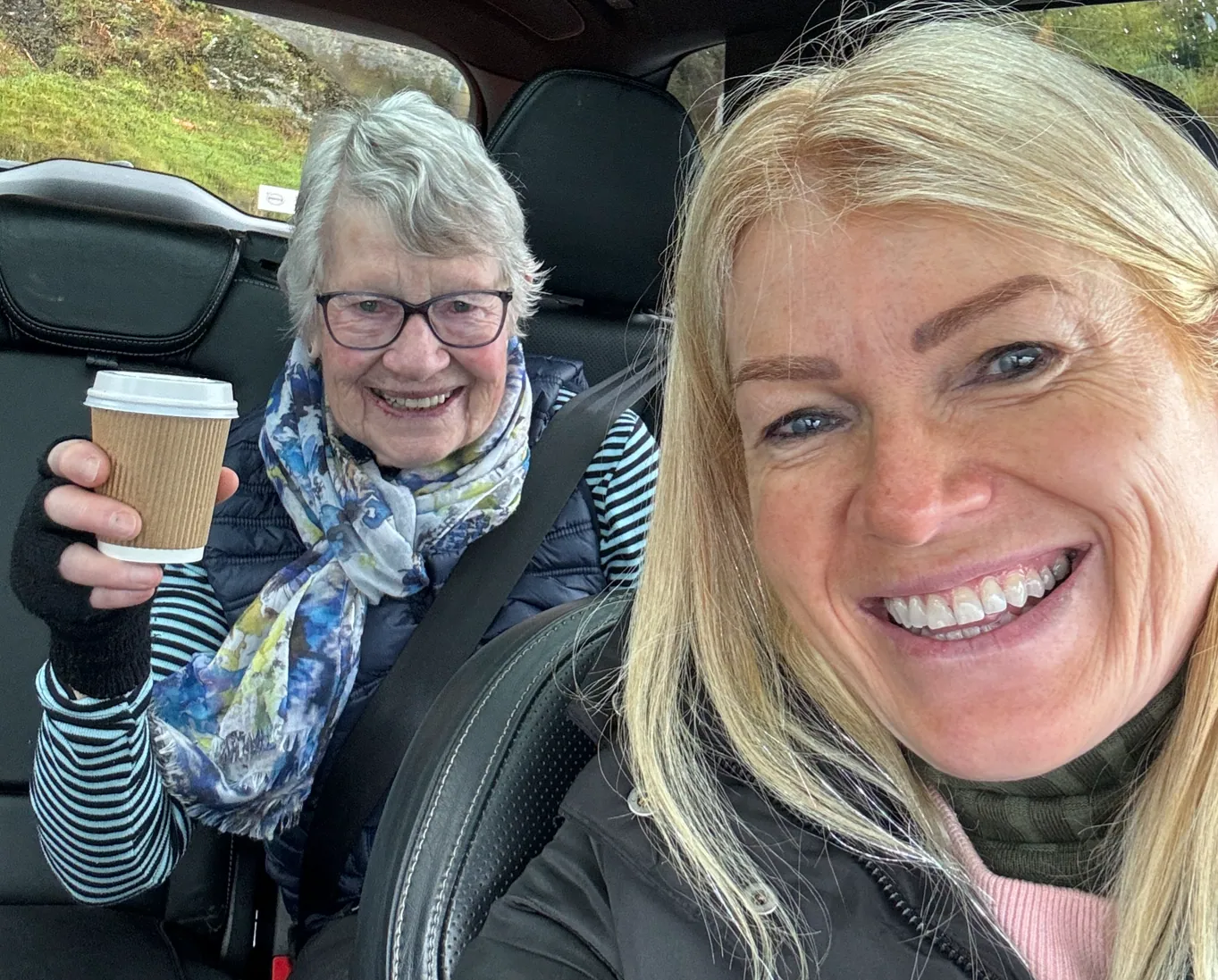 Caro Syson, founder of Your Final Matters, taking a selfie in the car with her mum, who is holding a takeaway cup